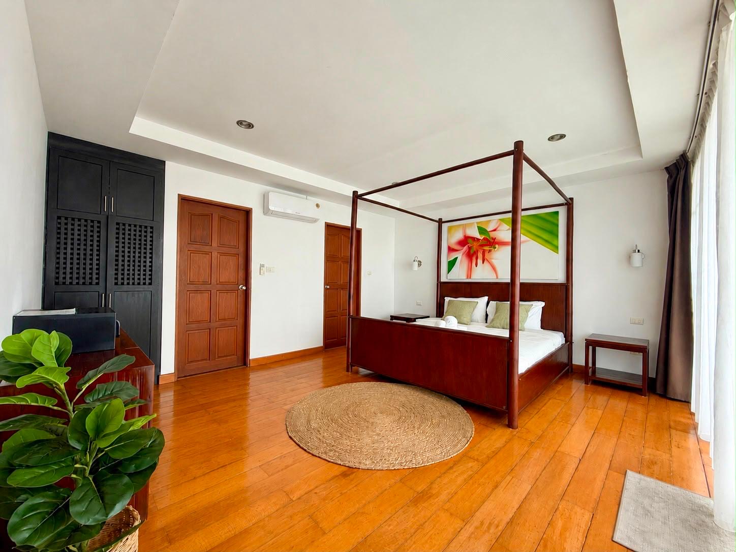 Master bedroom with four-poster bed and warm wood floors